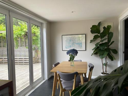a dining room with a wooden table and chairs at Chic Whangarei Retreat, walk to CBD in Whangarei