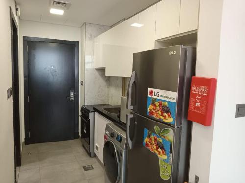 una cocina con nevera y lavadora en Studio in Business bay, Metro!, en Dubái