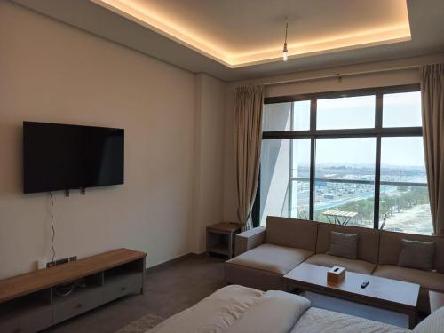 Una sala de estar con un sofá y una ventana grande. en Studio in Business bay, Metro!, en Dubái