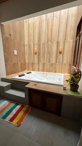 a bath tub in a bathroom with a wooden wall at POUSADA IRMAOS ATINS in Atins