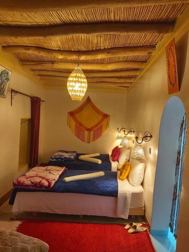a bedroom with a bed and a chandelier at DAR DANI café restaurant in Boumalne