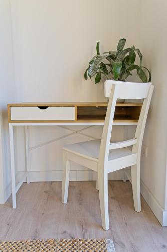 a white desk with a chair and a plant at Sunset Hills Transylvania in Odorheiu Secuiesc
