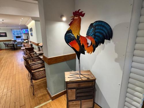 a statue of a peacock on a wall in a room at The Bell and Bottle in Hedgerley