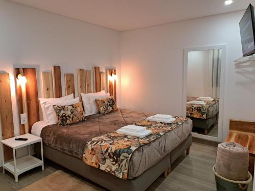 a bedroom with a large bed and a mirror at Agrafonte in Paços de Ferreira