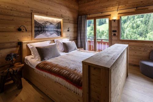 une chambre avec un lit dans une cabane en rondins dans l'établissement Résidence L'eclat Des Cimes - Chalet L'Eclat des Cimes - 12 Personnes - Morzine MAE-1921, à Morzine