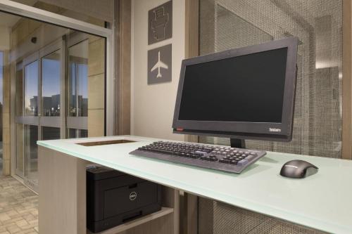 a computer monitor and a keyboard and mouse on a desk at Residence Inn by Marriott St. Paul Woodbury in Woodbury