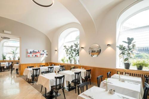 a restaurant with white tables and chairs and windows at Best Western Hotel Moran in Prague
