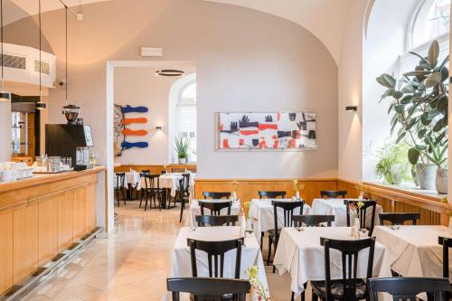 a dining room with white tables and chairs at Best Western Hotel Moran in Prague