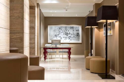 a lobby with a table and chairs and a painting at The Harmonie Vienna, BW Premier Collection in Vienna