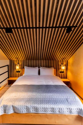 a bedroom with a large bed with a wooden ceiling at Комплекс відпочинку Крихая in Solochin