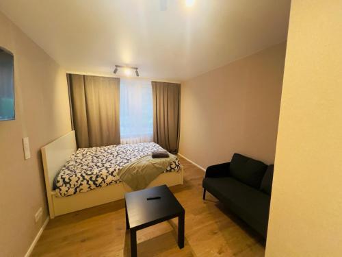 a small bedroom with a bed and a couch at studio apartment in Vilnius
