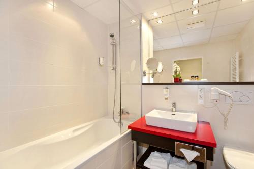 een witte badkamer met een wastafel en een douche bij Best Western Plus Plaza Hotel Graz in Graz