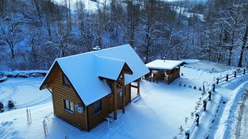 a log cabin with snow on the roof at Niedźwiedzia Dolina in Przybyszów