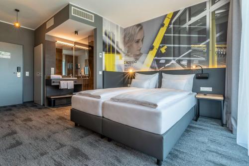 a bedroom with a large bed and a bathroom at Aiden by Best Western Stadtgut Hotel Steyr - FREE PARKING in Steyr