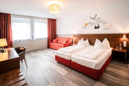 a hotel room with a bed and a red chair at Best Western Hotel am Walserberg in Wals