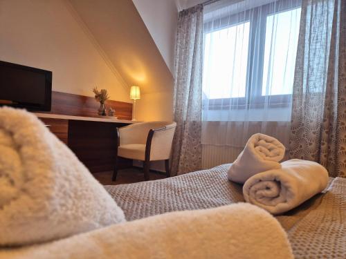 a hotel room with a bed with towels on it at B&B Penzión Magura in Bardejov