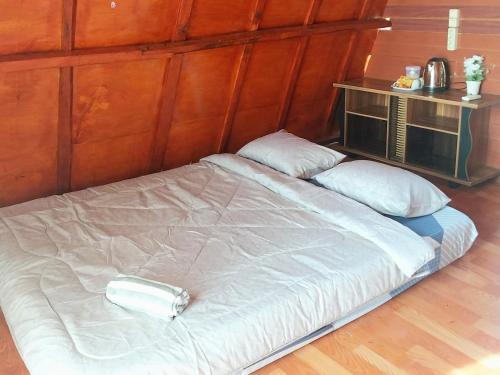 a large white bed in a room with wooden walls at Villa Mangrove Pulau Pahawang in Lampung