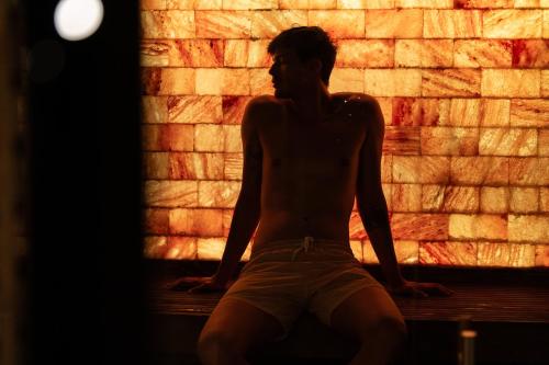 a man sitting on a bench in front of a brick wall at Corinthia Budapest in Budapest