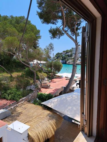 a view of a beach from the door of a house at Hostal Playa in Cala Santanyi