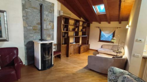 a living room with a stone fireplace and a couch at Sottocastello 2 in Gorizia