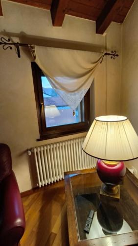 a lamp on a table in a living room with a window at Sottocastello 2 in Gorizia