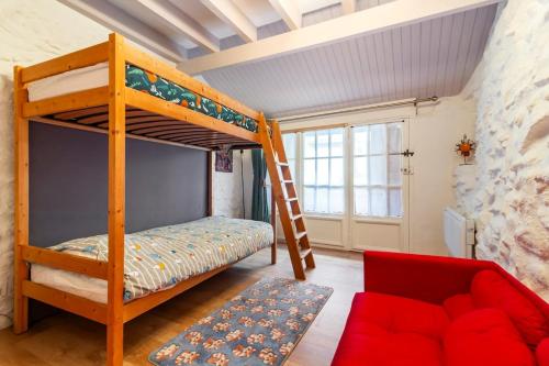 a bedroom with a bunk bed and a couch at La petite maison d 'Ascou in Ascou