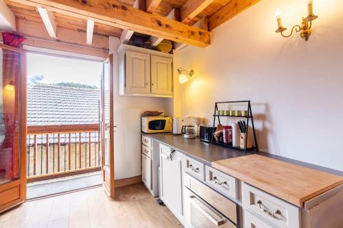 une cuisine avec des armoires blanches et un comptoir dans l'établissement La petite maison d 'Ascou, à Ascou