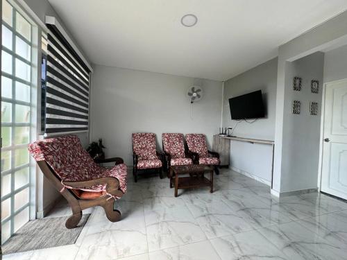 a living room with three chairs and a tv at Casa Campestre Bello Atardecer Cerca al Parque del Café con Piscina in La Esmeralda