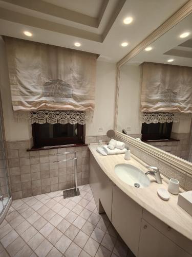 a bathroom with a sink and a large mirror at Sottocastello 2 in Gorizia