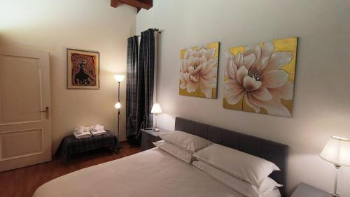 a bedroom with a bed and three paintings on the wall at Sottocastello 2 in Gorizia