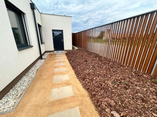 a walkway in front of a house with a fence at Rezidence Strachotín in Strachotín