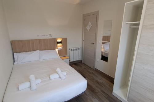 a bedroom with a large white bed with white pillows at El Rincón del Navegante in San Vicente de la Barquera