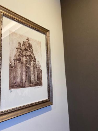 a framed picture of a building on a wall at Le Due Torri ROOMS in Oristano
