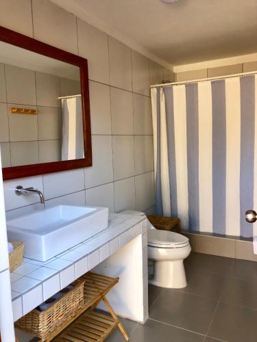 a bathroom with a sink and a toilet and a mirror at Casa Pacifico in Los Órganos