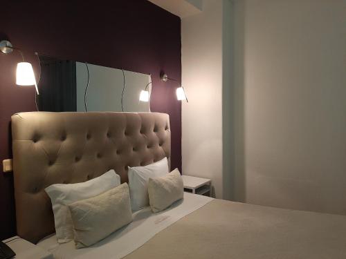a bedroom with a large bed with two pillows at Hotel Kamanga in Tomar
