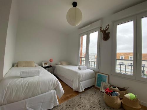 a bedroom with two beds and two windows at New Apartment Disneyland Paris Panoramic view 8 PAX, 2 parking in Serris