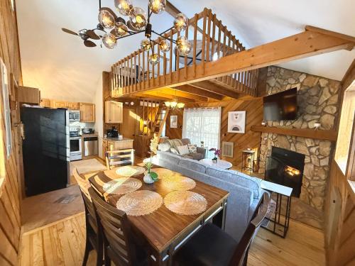 a dining room and living room with a wooden table at Plentiful Porches - Hot Tub - King Bed - Views in Banner Elk