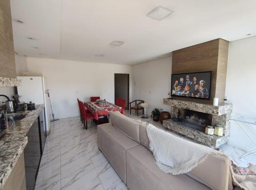 una sala de estar con un sofá y una chimenea en Vanessa pousada familiar, en São Gabriel