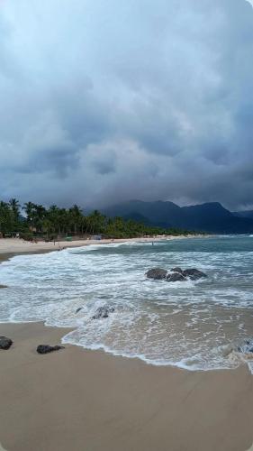 einen Strand mit Felsen im Sand und dem Meer in der Unterkunft Condominio Stoneville in São Sebastião