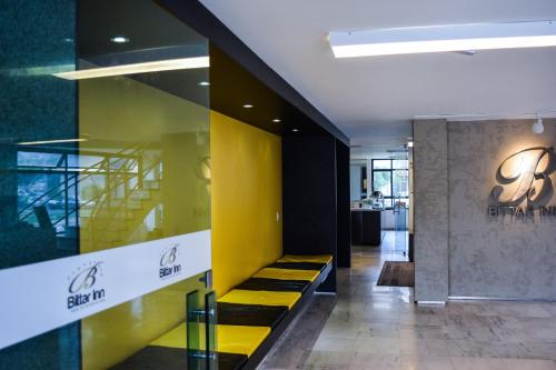 a lobby with a yellow wall and a yellow staircase at Bittar Inn in Brasilia