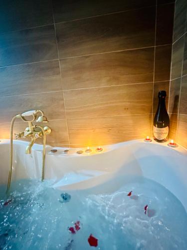 - Baño con bañera y botella de vino en Apartamento Rei Center, en Mérida