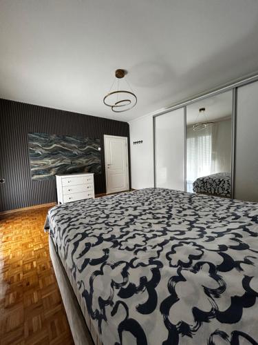 a bedroom with a bed with a black and white comforter at Private luxurious house with pool for 15 people in Tivat