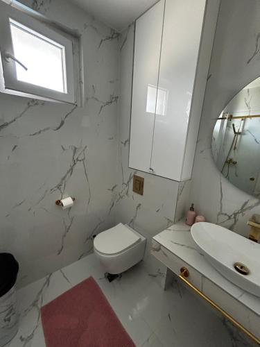 a white bathroom with a toilet and a sink at Private luxurious house with pool for 15 people in Tivat