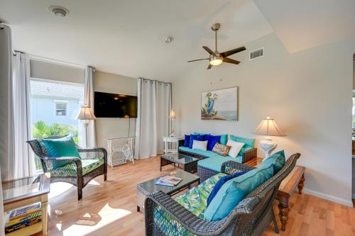 a living room with a blue couch and chairs at Sunny Marco Island Gem with Shared Pool and Dock! in Marco Island
