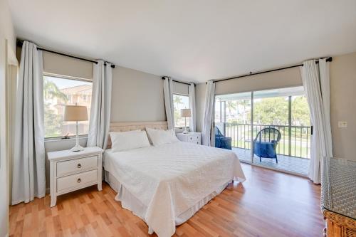 a bedroom with a bed and large windows at Sunny Marco Island Gem with Shared Pool and Dock! in Marco Island