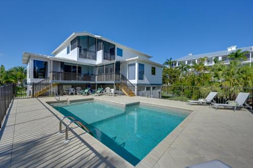 a house with a swimming pool in front of a house at Sunny Marco Island Gem with Shared Pool and Dock! in Marco Island