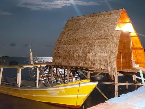 a yellow boat with a straw roof on the water at Villa Mangrove Pulau Pahawang in Lampung