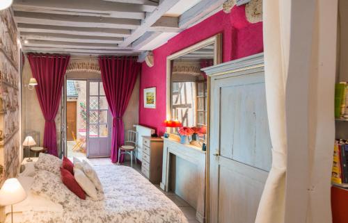 a bedroom with pink walls and a bed at Le Nid De La Loire in Blois