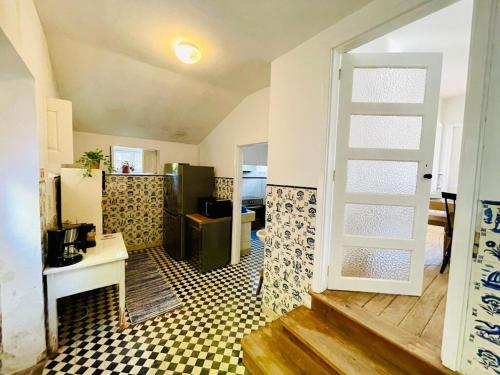 een kamer met een keuken met een deur en een vloer bij Historic Douro Valley Quinta in Lamego
