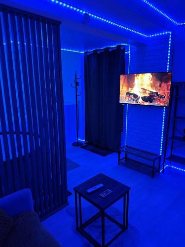 a living room with a tv in a blue room at Studio Cosy avec Spa in Corbeil-Essonnes
